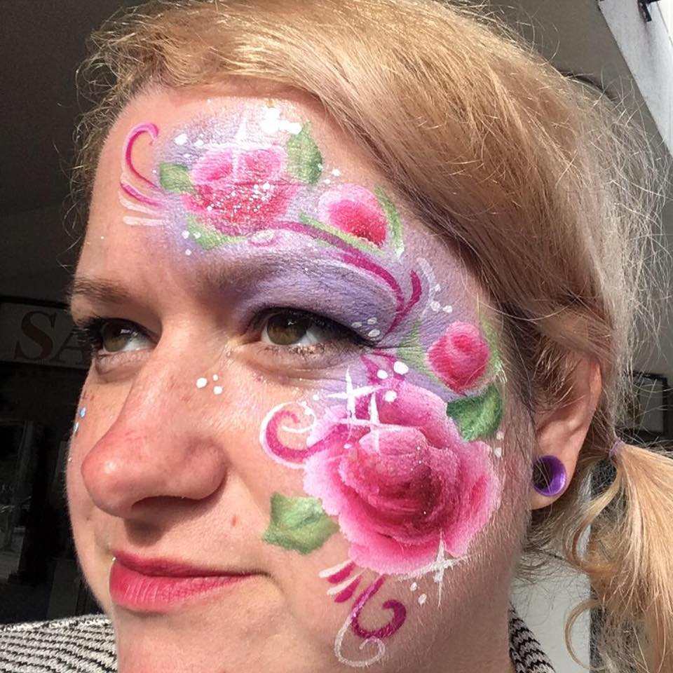 Adult with elegant floral face painting design perfect for special occasions