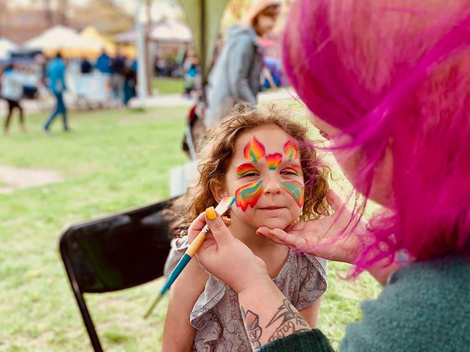 Professional facepainting artist creating beautiful designs at children's event